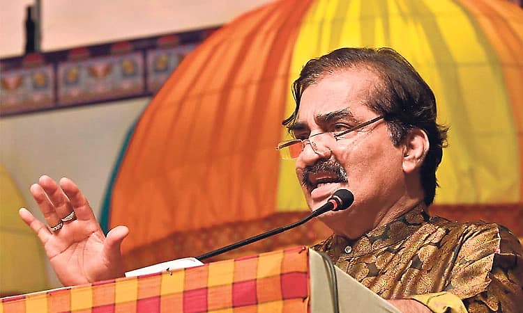 Dr. M. Mohan Alva speaking at a microphone on stage